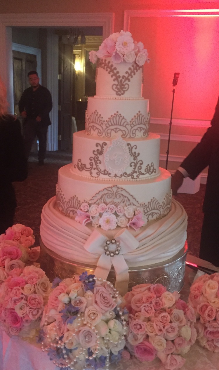 Beautiful wedding cake with florist bouquets at Oheka Castle